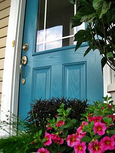 a blue door with pink flowers in front of it