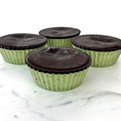 three chocolate cupcakes sitting on top of a marble counter