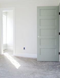 an empty room with white walls and gray doors