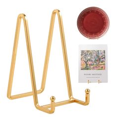 a set of two gold plate holders and a card holder with a red glass on it