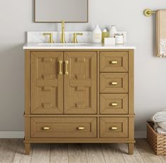 a bathroom vanity with two sinks and gold faucets on the top, in front of a mirror