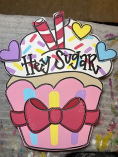 a sticker that says hey sugar on top of a cupcake with a bow