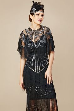 This vintage-inspired retro style dress caters perfectly to 1920s fashion. It's the incarnation of elegance and flair. With fringes swaying with your every movement, it can be deemed as truly flapper. Features: V-neck design Flapper fringe columns Complimentary cape Dazzling sequins 100% Polyester fabric Note: This dress comes with an unique size chart. Be sure to select your ideal fit from the chart before making your purchase. Note: This item is limited to GROUND SHIPPING ONLY. If expedited sh Fitted Beaded Fringe Flapper Dress, Gatsby Style Beaded Fringe Flapper Dress For Evening, Fitted Flapper Dress With Beaded Fringe For Costume Party, Fitted Beaded Fringe Flapper Dress For Costume Party, Gatsby Style Beaded Fringe Flapper Evening Dress, Flapper Dress With Beaded Fringe For Night Out, 1920s Style Fitted Dress With Beaded Fringe, Night Out Flapper Dress With Beaded Fringe, Black 1920s Flapper Dress For Costume Party