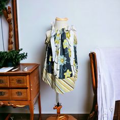 a dress on a mannequin in front of a mirror and table with a chair