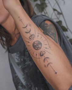 a man with a tattoo on his arm that shows phases of the moon and stars