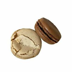 two macaroons are sitting next to each other on a white surface, one has been bitten and the other is half eaten