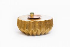 a small potted plant sitting on top of a wooden table with a gold plate