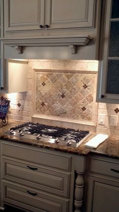 a kitchen with white cabinets and granite counter tops, along with marble tile backsplash