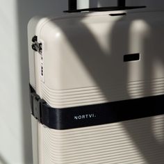 a white piece of luggage sitting on top of a floor