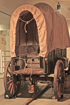 an old covered wagon is on display in a museum