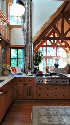 a large kitchen with wooden cabinets and an island in front of the stove top oven