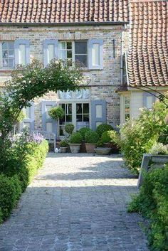 an old brick house with stone walkway leading to the front door