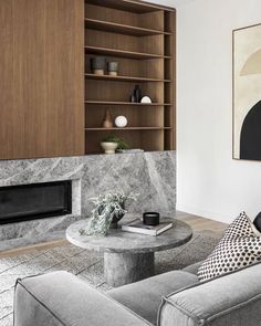 a living room filled with furniture and a fire place next to a wall mounted book shelf