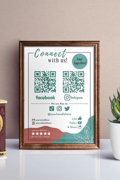 a photo frame with a qr code on it next to a potted plant