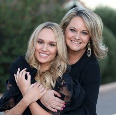 two women are hugging each other outside