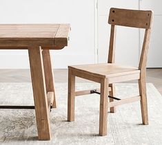 a wooden chair sitting next to a table on top of a rug