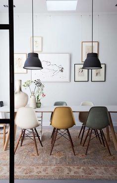 a dining room table with four chairs and two vases on it's side