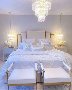 a bedroom with a bed, two chairs and a chandelier