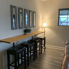 a living room filled with furniture next to a wall mounted flat screen tv on top of a wooden shelf