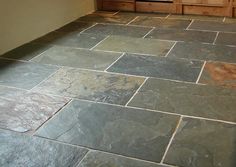 a kitchen with stone flooring and cabinets in the backround, next to an oven