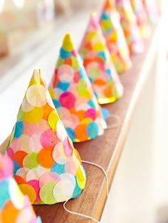 colorful party hats are lined up on a shelf