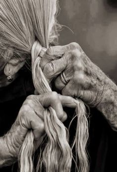 an old woman is braiding her hair in black and white, with the caption ompabaka com