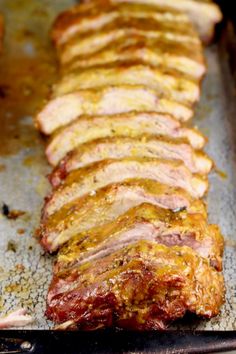 sliced meat sitting on top of a pan covered in seasoning next to other food items