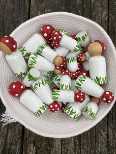 a white bowl filled with red and green candies on top of a wooden table