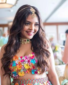 a woman in a colorful outfit with flowers on her chest