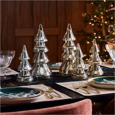 the table is set with silver christmas trees