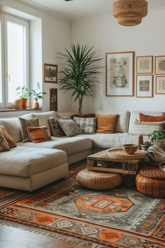 a living room filled with lots of furniture next to a large potted palm tree