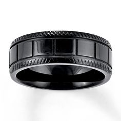 a black wedding band with an intricate design on the inside and outside, is shown against a white background