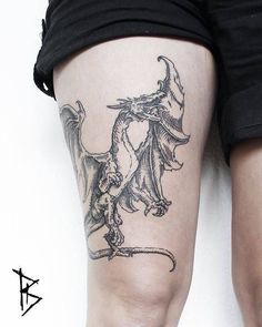 a woman's leg with a dragon tattoo on it and an arrow in the middle