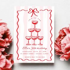 a red and white card with three wine glasses on it next to pink carnations