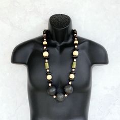 This long beaded necklace was handmade using a stylish mix of tribal beads including distressed black wooden rondelles, 25mm round beige wood beads, olive green ceramic tubes, a variety of small wooden brown beads, geometric beige wood beads, and three HUGE 40mm round distressed black wooden beads. An amazing one of a kind piece! The necklace measures 35 inches in length and is securely fastened with a sterling silver toggle clasp. Perfect for any gender! Length can be adjusted if needed - just Handmade Black Earthy Jewelry, Earthy Wooden Beaded Necklaces, Black Wooden Beads For Jewelry Making, Artisan Black Necklaces With Large Beads, Artisan Black Beads With Large Beads, Black Artisan Necklace With Large Beads, Black Wooden Beads Bohemian Style, Artisan Black Necklace With Large Beads, Artisan Black Necklace With Round Beads