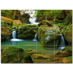 a waterfall in the forest with mossy rocks