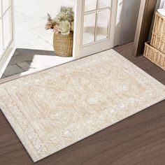 a beige area rug on the floor in front of an open door with a basket full of flowers next to it