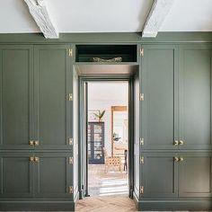 an empty room with green cupboards and wood flooring on the side walk way