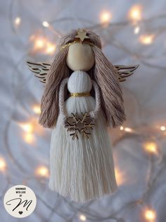 an angel ornament hanging from a christmas tree