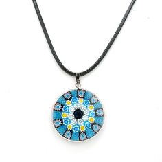 From the Italian for "thousand flowers," Millefiori jewelry is famous for its beautiful and intricate designs. This authentic round Millefiori necklace features bright shades of blue colors in a mosaic pattern. The black cord necklace measures about 18", with a silver-plated clasp. The pendant rim and necklace clasp are also silver-plated. At 1 1/4", the glass pendant is sizable and sure to make a statement. Because no two necklaces are exactly alike, yours may be slightly different than the one Flower Pendant Necklace With Adjustable Cord, Blue Necklace With Adjustable Cord As Gift, Blue Adjustable Cord Necklace For Gift, Adjustable Multicolor Medallion Necklace, Adjustable Blue Flower Pendant Necklace, Adjustable Blue Medallion Necklace, Blue Round Pendant Necklace, Blue Necklace With Round Pendant, Adjustable, Adjustable Blue Round Pendant Necklace