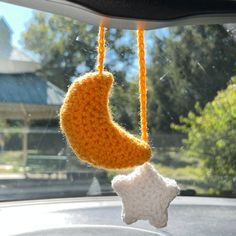 a crocheted crescent and star hanging from a car's dash board window