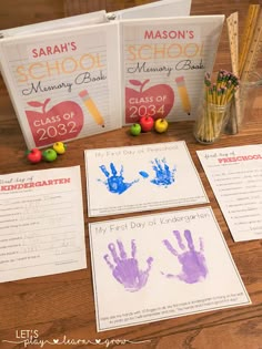 three books with handprints and pencils next to them on a wooden table