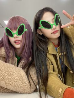 two girls with green sunglasses posing for the camera