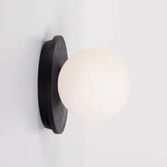 a light that is on the wall next to a white wall mounted object with a black frame