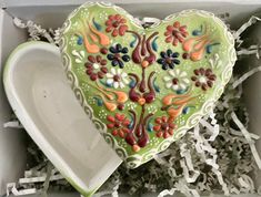 a decorative heart shaped dish in a box