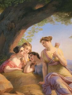 three women sitting under a tree in front of a body of water