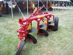 a red and yellow tractor with two plow attachments attached to it's sides