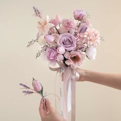 a person holding a bouquet of flowers in their hand