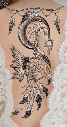 the back of a woman's body with tattoos and feathers on her stomach,