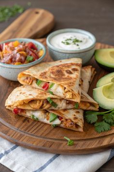 three quesadillas on a wooden platter with salsa and avocado